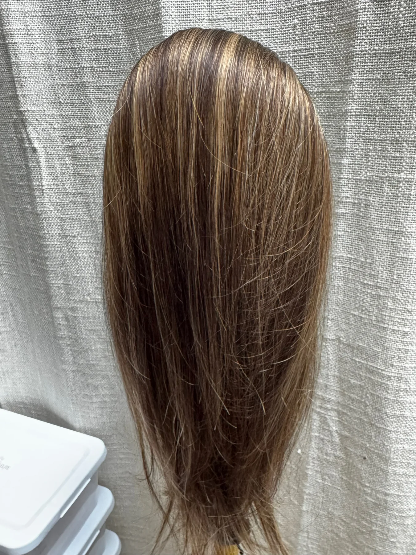 Straight brunette ponytail hairpiece with caramel highlights displayed on a stand