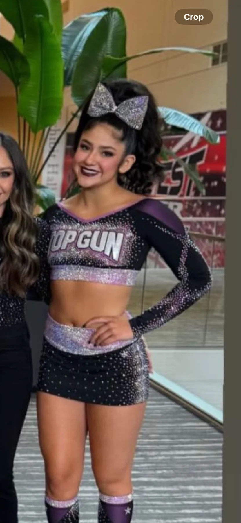 Top Gun cheerleader wearing a black curled ponytail and oversized silver rhinestone bow
